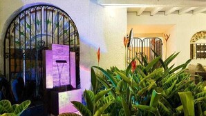 A courtyard with a wrought iron gate, a water feature, and lush green plants. - Luxury Air Road (Medellín)