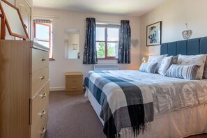 A bedroom with a bed, dresser, and window with curtains. - 2 Bed in Croyde (oc-sscape) (Croyde)