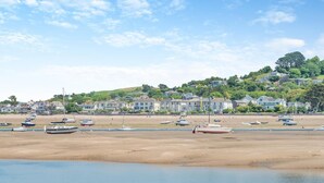 A coastal beach with boats, houses, and a hilly background. - 2 Bed in Appledore (oc-whimbc) (Appledore)