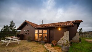 A rustic house with a brown exterior, large windows, and a tiled roof. - Villa Miramar at Casa Marin Vineyards (Cartagena)
