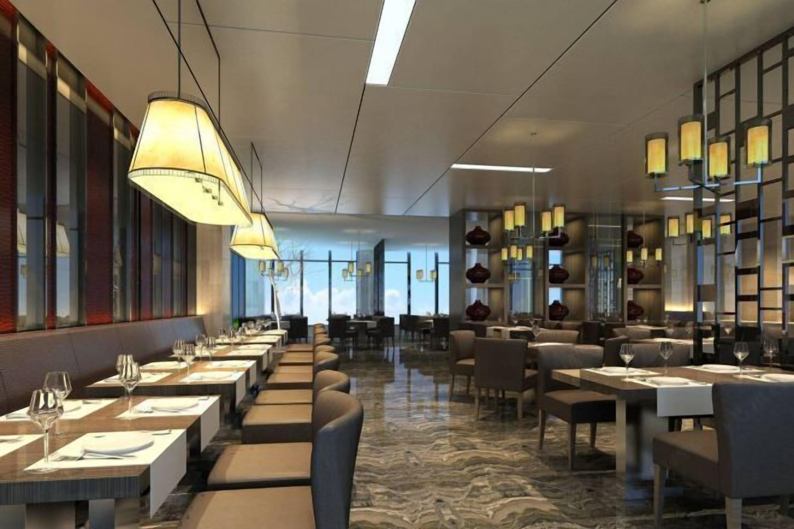 Un restaurante moderno con mesas largas, iluminación ambiental y suelo de mármol.