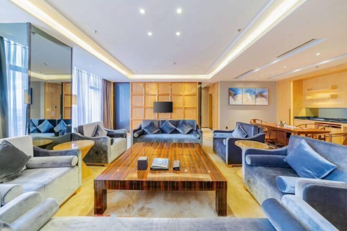 Ein modernes Wohnzimmer mit Couch, Fernseher und einem Couchtisch in der Mitte.