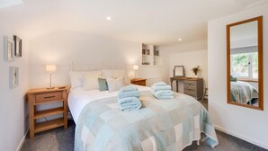 A bedroom with a bed, bedside tables, a dresser, a mirror, and a shelf with books. - 2 Bed in Parracombe (oc-cottag) (Trentishoe)