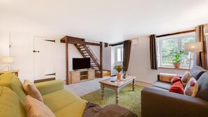 A modern living room with a staircase, a flat-screen TV, a coffee table, and two sofas. - 2 Bed in Parracombe (oc-cottag) (Trentishoe)