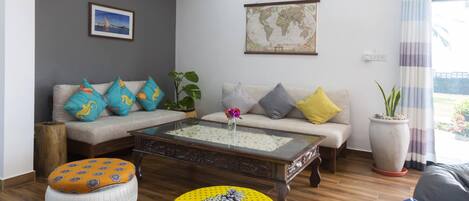 Sala de estar con sofá, mesa de centro y planta en maceta.