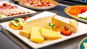 Ein Buffet mit einer Auswahl an Käse, Obst und Fleisch.