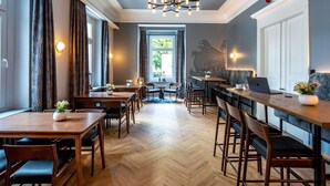 Un restaurante con mesas y sillas de madera, una zona de bar y vistas al exterior.