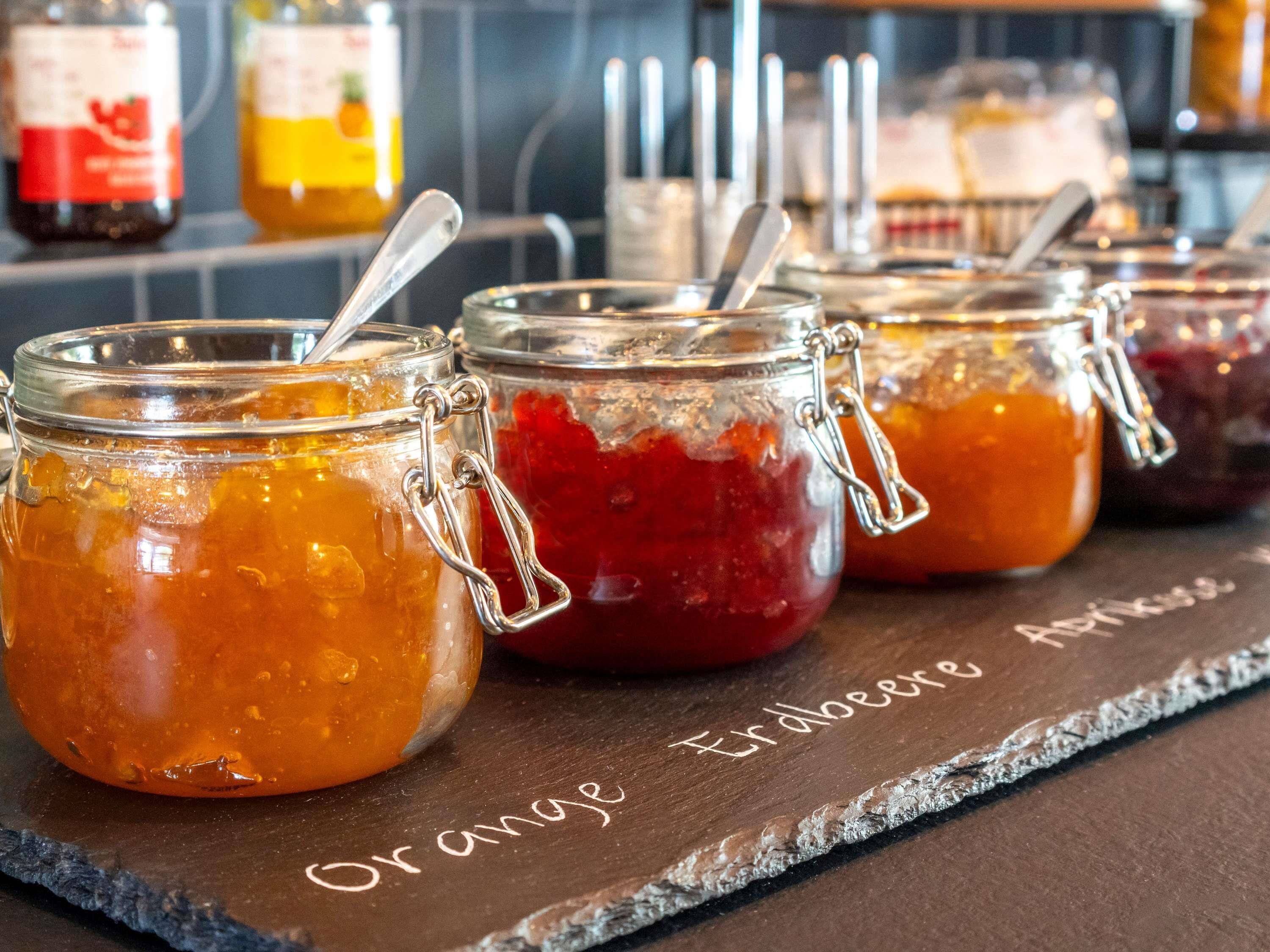 A variety of jars with metal clasps, likely containing food items, arranged on a shelf.