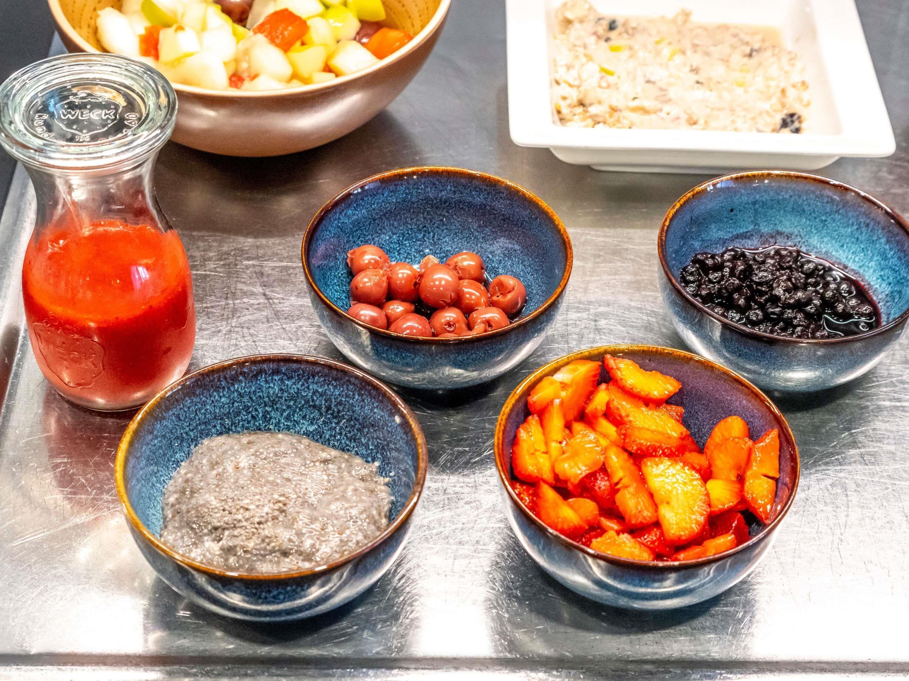 A table with various food items and a bottle of sauce.