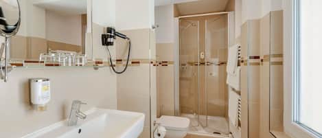 A modern bathroom with a glass-enclosed shower, a sink, and a toilet.