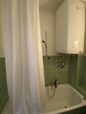 Bathtub, hair dryer, towels, toilet paper