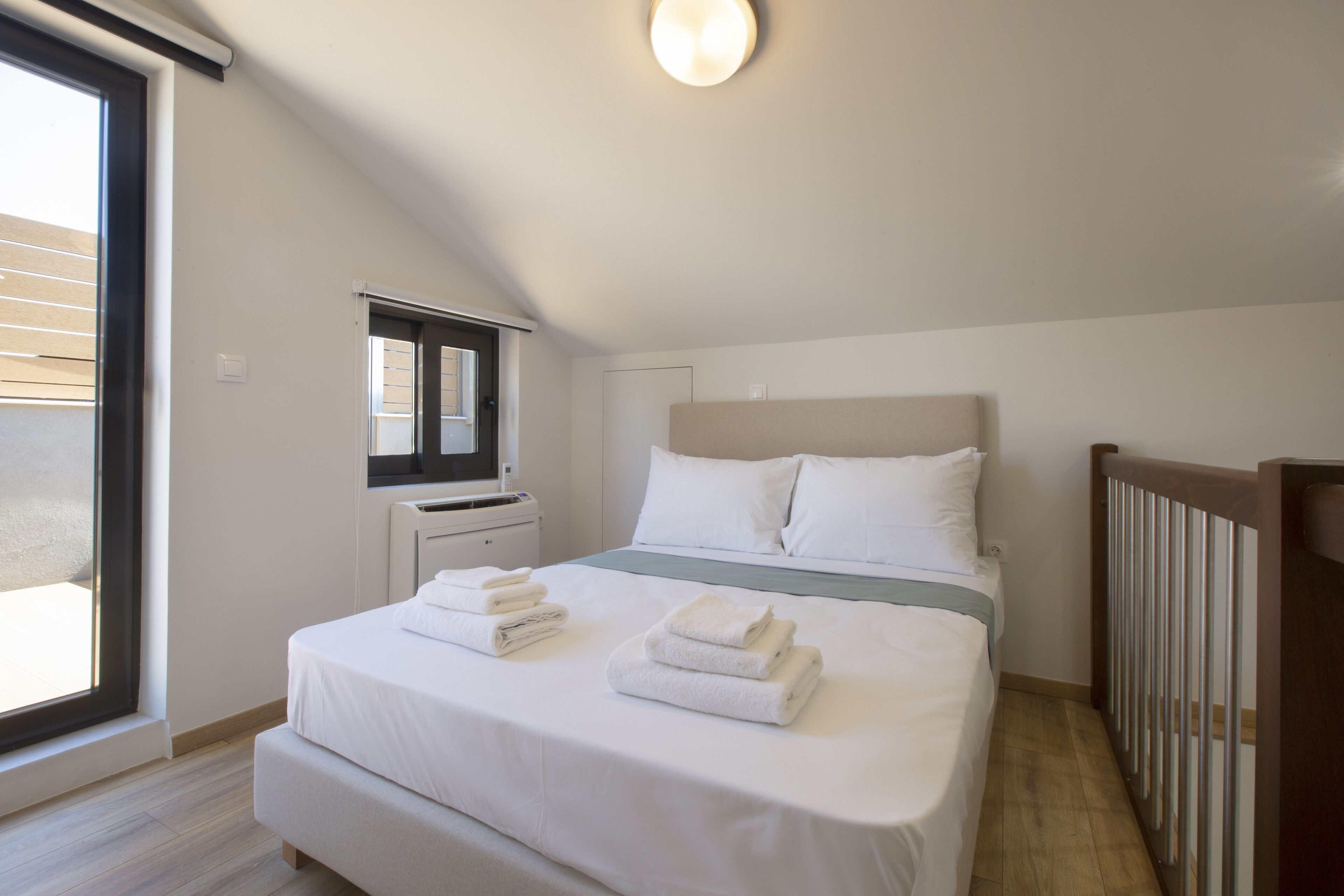 Une chambre à coucher avec un lit, une fenêtre, un radiateur et une vue sur l’extérieur.