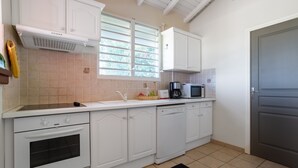 A modern kitchen with white cabinetry, a built-in oven, a microwave, and a dishwasher.