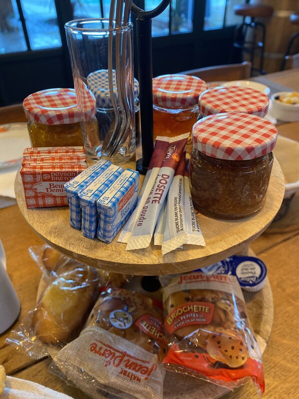 Un soporte de madera con tarros de miel, panales y productos con sabor a miel.