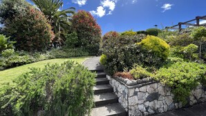 A landscaped garden with a stone staircase leading up to a wooden deck.