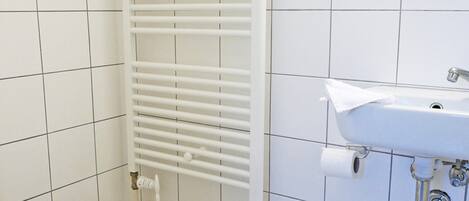 A bathroom with a toilet, a sink, and a towel rack.