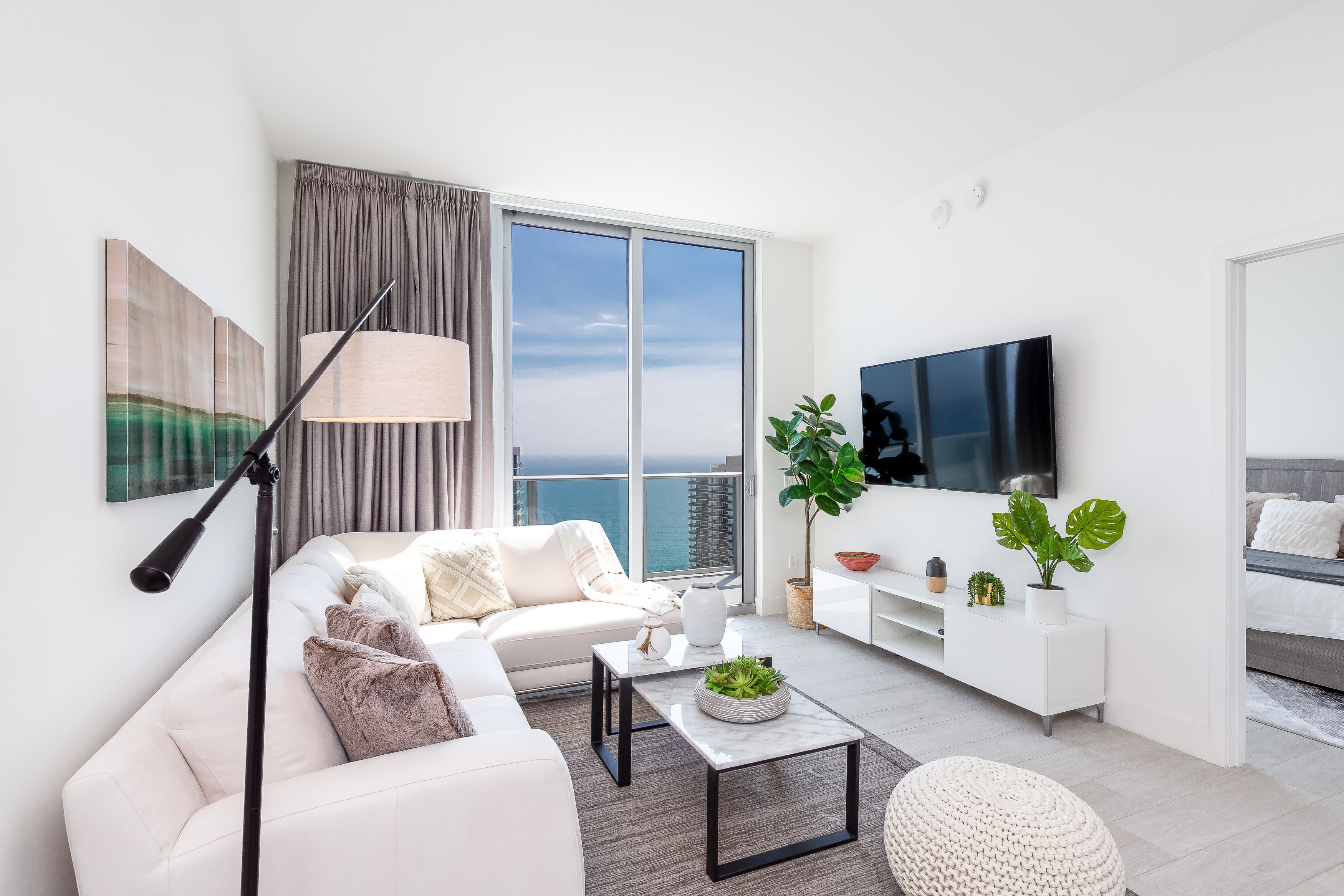 Una sala de estar moderna con sofá, mesa de centro y televisor.