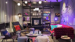 Una sala de estar moderna con un sofá, sillones, una mesa de centro y una estantería.
