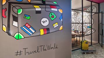 Una pared con una ilustración de una maleta y el hashtag #TravelTheWorld.