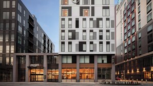 A modern hotel with a prominent logo on the facade, large windows, and a well-lit entrance. - Element by Marriott Iowa City (Iowa City)