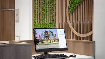 Un monitor de computadora mostrando un sitio web de hotel, un teclado y un ratón sobre un escritorio.