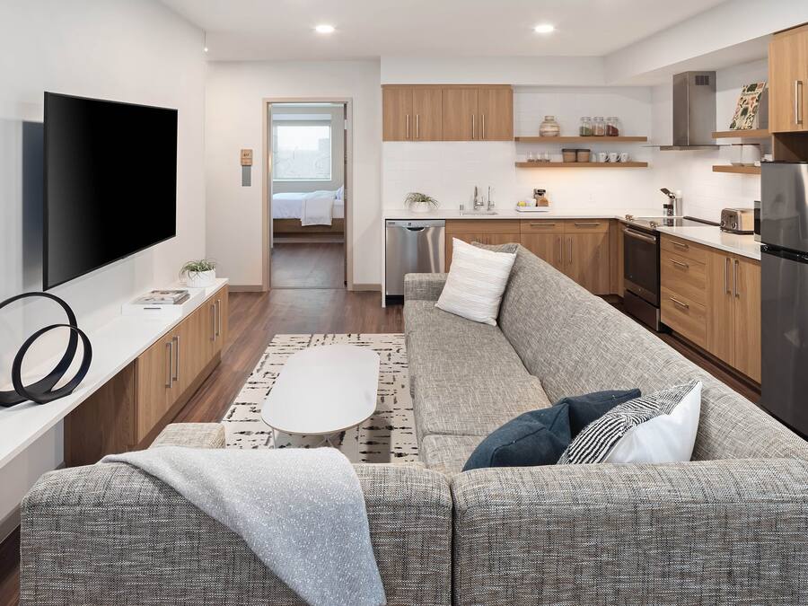 A modern kitchen with wooden cabinets, a stainless steel refrigerator, and a built-in dishwasher.