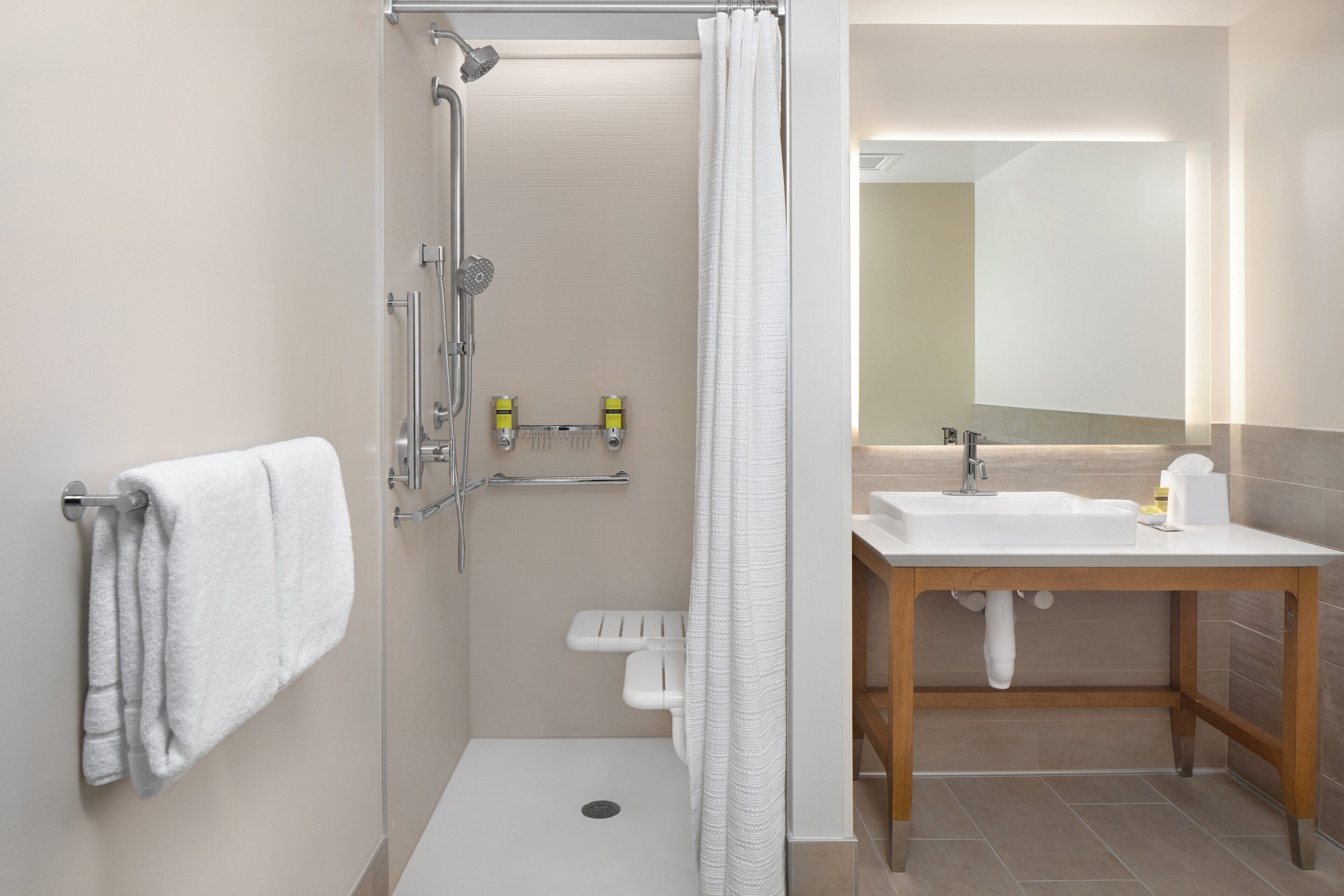 A modern bathroom with a shower, toilet, and sink.