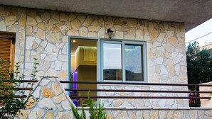 A stone building with a balcony, a window, and a door. - Luxury guesthouse nature (Nafplio)