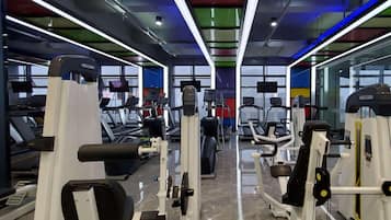 Un gimnasio con cintas de correr, máquinas de pesas y equipamiento de ejercicio.