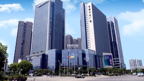 A modern high-rise building with a glass facade, multiple floors, and a prominent entrance. - Days Hotel Suites By Wyndham Zixin Changsha (Changsha)