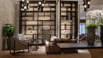 Un interior moderno con estantería de madera, zona de estar e iluminación decorativa.