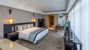 A modern hotel room with a large bed, bedside tables, a desk, and a television. - Days Hotel Suites By Wyndham Zixin Changsha (Changsha)