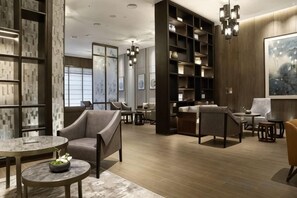 A modern interior with a seating area, bookshelves, and a large artwork on the wall.