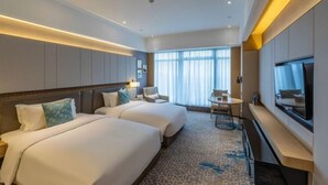 A hotel room with two beds, a TV, a desk, and a large window with curtains. - Days Hotel Suites By Wyndham Zixin Changsha (Changsha)