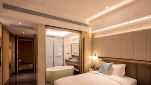 A hotel room with a large bed, a separate bathroom, and a walk-in closet. - Days Hotel Suites By Wyndham Zixin Changsha (Changsha)