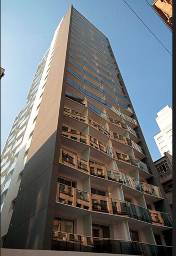 A high-rise building with multiple balconies and a modern architectural design.