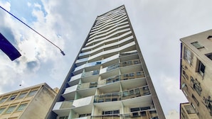 Un edificio de gran altura con múltiples balcones, amplias ventanas y un diseño arquitectónico moderno.