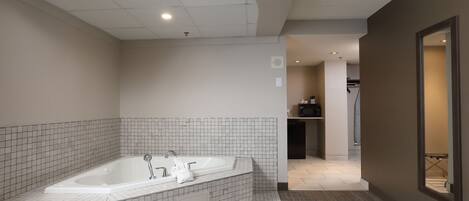 A modern bathroom with a freestanding bathtub, tiled walls, and a carpeted floor.