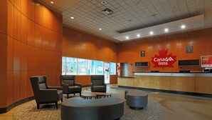 Die Lobby der Canada Inn mit einer Rezeption, einer Sitzecke und Informationspostern.