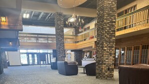 A spacious lobby with a patterned carpet, a reception desk, and a chandelier. - Canad Inns Destination Centre Portage la Prairie (Portage La Prairie)