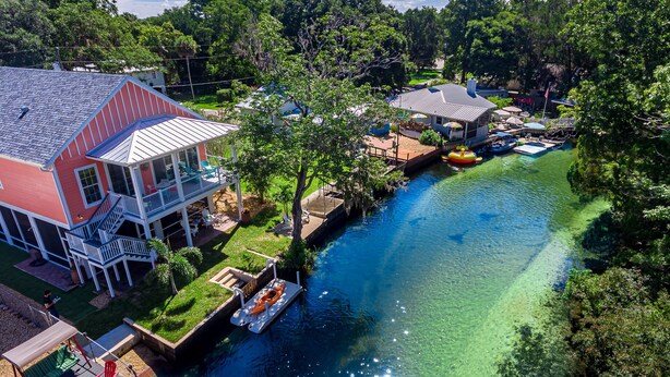Una casa con muelle, piscina y río.