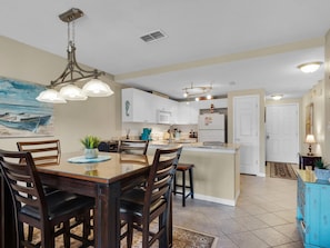 A modern kitchen with white cabinets, a central island, and pendant lighting.