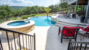 Una piscina con hidromasaje, mobiliario de exterior y vistas del paisaje circundante.