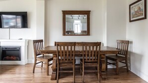 A dining area with a wooden table and chairs, a fireplace, and a mounted mirror above the table. - 5-bedroom home perfect for families/ groups. Located just minutes DT Vancouver (Vancouver)