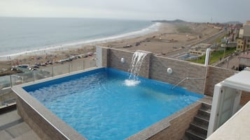 Una piscina al aire libre de temporada, sombrillas