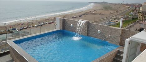 Una piscina al aire libre de temporada, sombrillas
