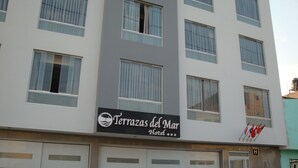 Un hotel chiamato "Terrazas del Mar Hotel", con numerose finestre e una insegna.