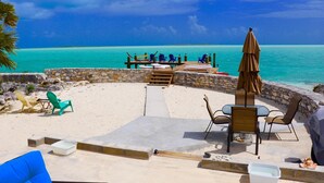 A beachside patio with outdoor seating and a view of the ocean. - Amazing Beachfront home the calm side of the island. Swimming & kayaking (Exuma)