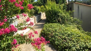 A garden with flowering plants and a pathway. - Homerez - House in Saint-Martin-de-Brômes (Saint-Martin-de-Brômes)