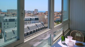 Ein Balkon mit Tisch, einer Flasche und einem Stuhl.